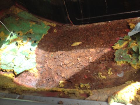 1978 Ford Bronco - The floor pan shows extensive rust damage and deteriorated insulation.