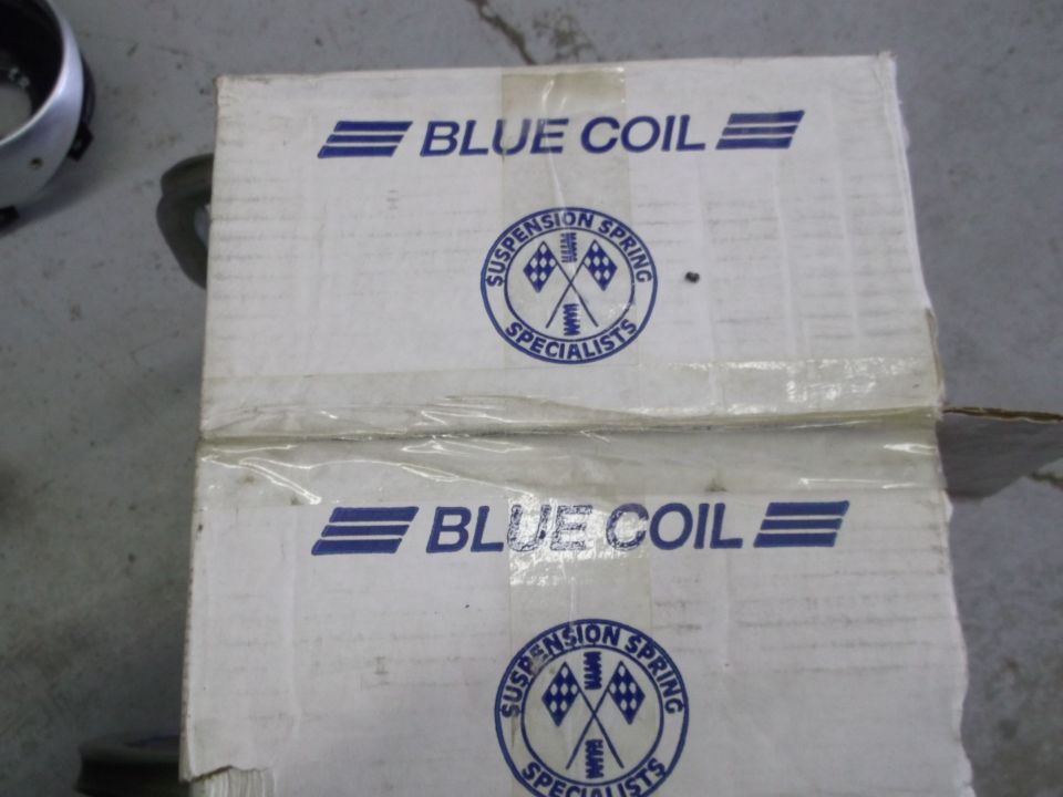 Two stacked cardboard boxes with "BLUE COIL" and "SUSPENSION SPRING SPECIALISTS" logos