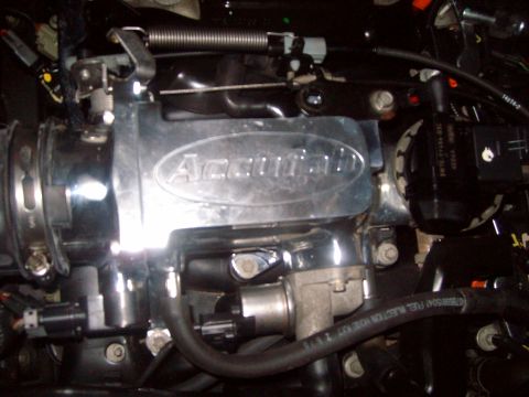 2004 Ford Crown Victoria - Close-up of engine components, including a chrome throttle body and various hoses.