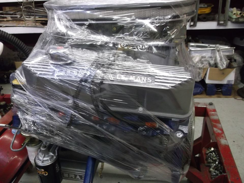 engine with "LE MANS" on valve cover, wrapped in plastic