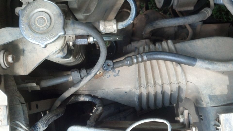 Power steering rack and pinion with hoses and warning cap