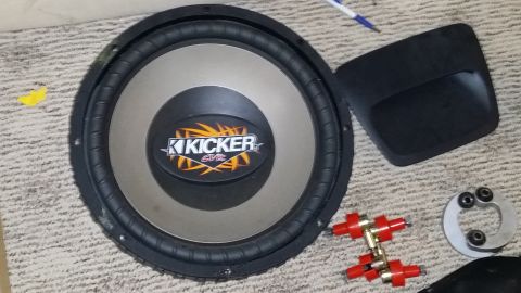 2007 Subaru Impreza - Car audio components including a Kicker subwoofer and various connectors are laid out on a carpeted surface.
