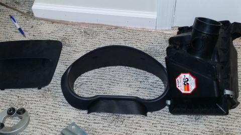 2007 Subaru Impreza - Car parts including dashboard trim, an instrument cluster shroud, and an air intake system are laid out on a carpeted floor.