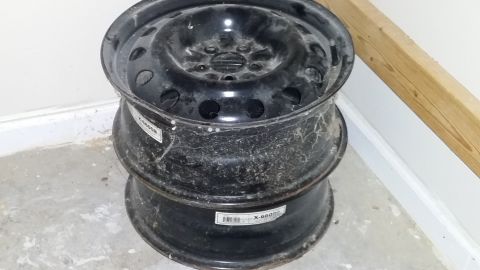 2007 Subaru Impreza - Two steel wheels are stacked on a floor, showing labels with part numbers.