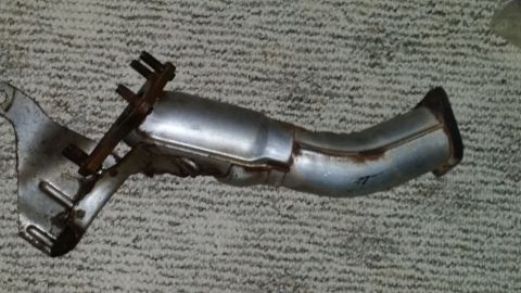2007 Subaru Impreza - A used exhaust pipe with visible rust and a metal bracket is shown against a textured background.