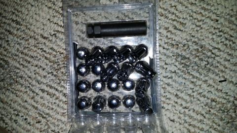 2007 Subaru Impreza - A package containing chrome lug nuts and a socket is shown on a carpeted surface.