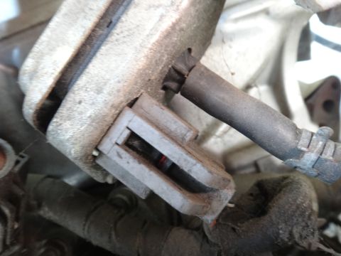 1993 Ford Taurus - A close-up view of a dusty electrical connector and a black hose attached to a vehicle's engine.