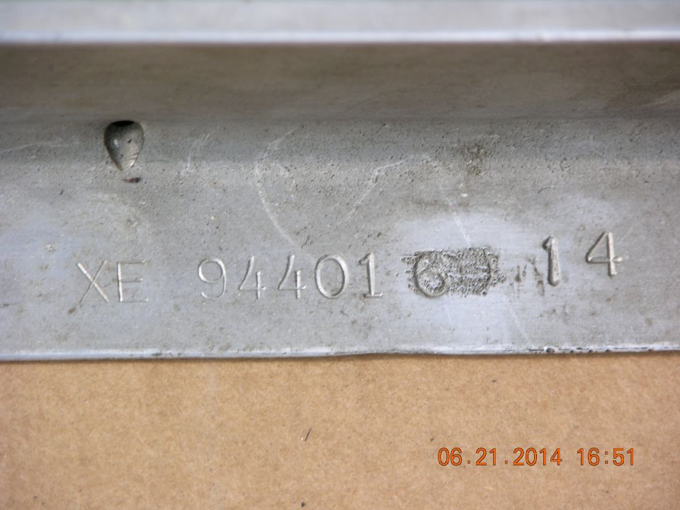Metal part stamped with XE 94401 6 14 and a date stamp 06.21.2014 16:51
