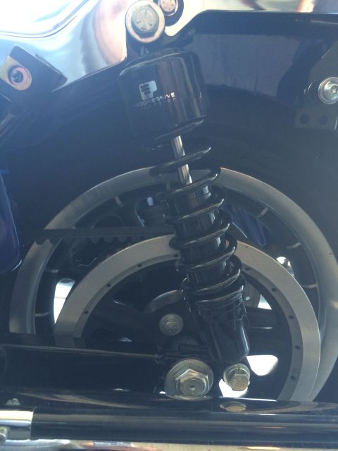 2007 Harley-Davidson Electra Glide Clsc - Close-up of a motorcycle's rear suspension and wheel assembly, showing a shock absorber and belt drive system.