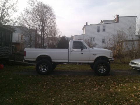 1995 Ford F-350 - This lifted 1995 Ford F-350 pickup truck is shown from the side in a residential setting.