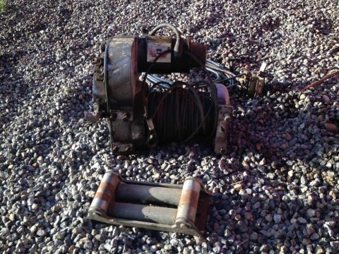 1978 Ford Bronco - A winch and roller fairlead are shown resting on a gravel surface.