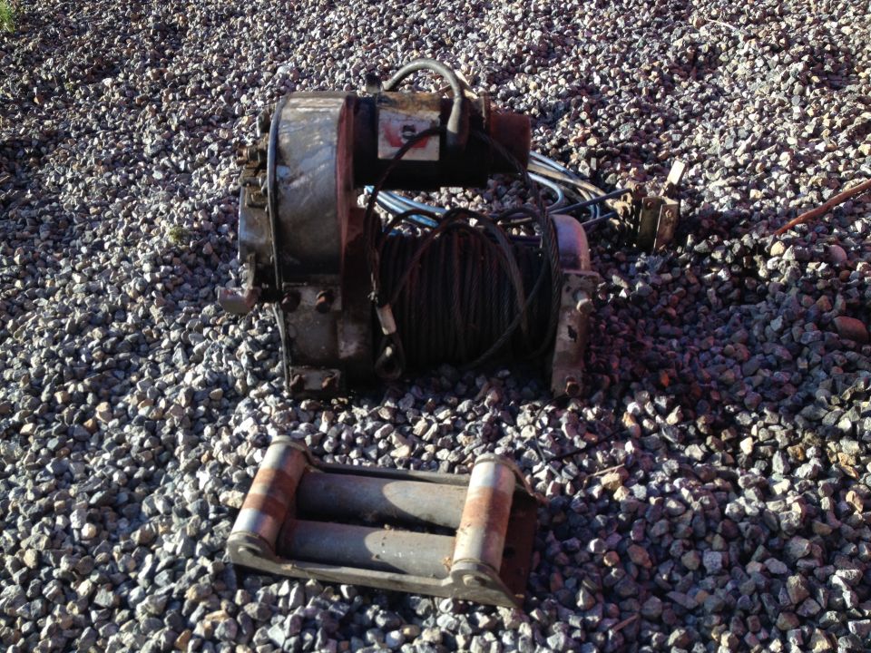 Winch with cable and a roller fairlead on gravel