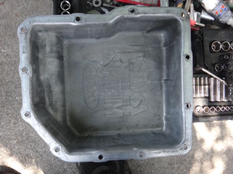1993 Ford Taurus - An aluminum oil pan with embossed Ford branding is shown next to a toolbox with sockets.