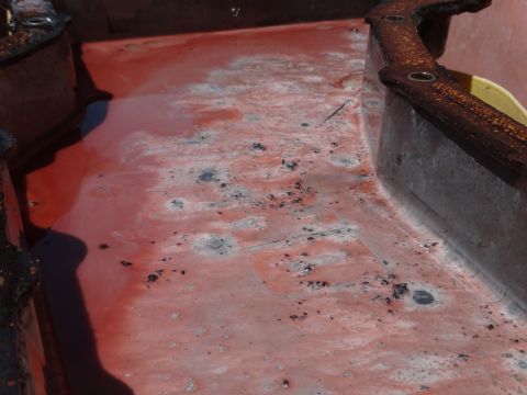 1993 Ford Taurus - A close-up view of a metal container filled with red liquid and debris, showing signs of rust and wear.
