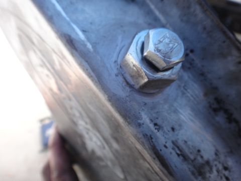1993 Ford Taurus - A close-up view of a bolt and nut assembly on a metallic component, with some visible wear and discoloration.