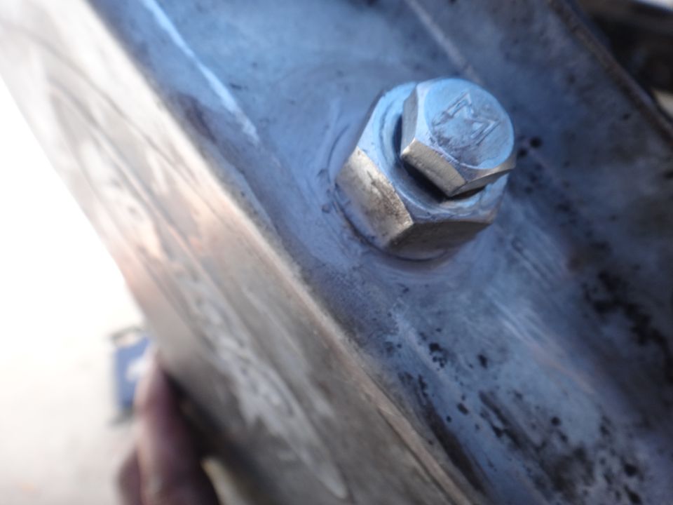 Close-up of a bolt and nut on a metal surface