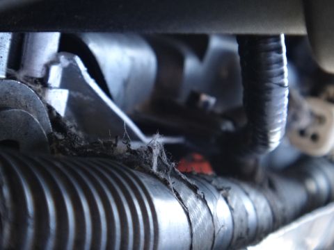 1993 Ford Taurus - Close-up view of aged engine components, showing wear and tear on a metal pipe and wiring.