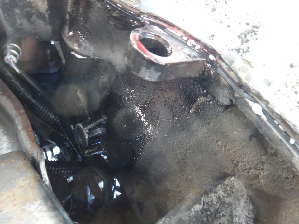Close-up of a greasy engine component with a small gear visible