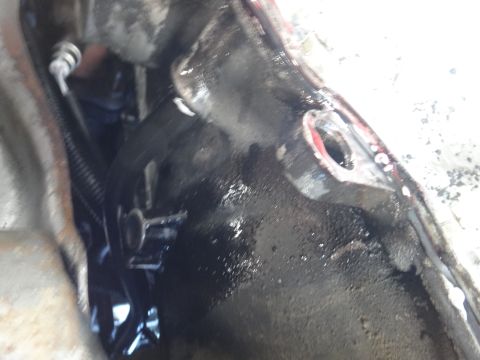 1993 Ford Taurus - Greasy engine or transmission part with a bolt hole visible.
