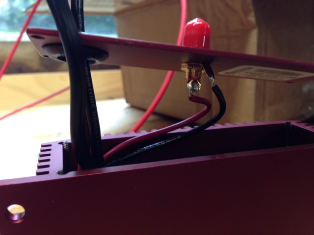 close-up of red electronic box with wires connected to a circuit board and a red antenna-like object