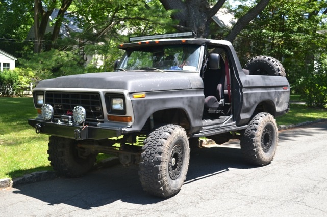 Gray 1978 Ford Bronco with lifted suspension, off-road tires, and light bar
