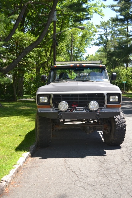 1979 Ford Bronco - This lifted 1978 Ford Bronco features a custom bumper and auxiliary lights, presented in a front-facing view.