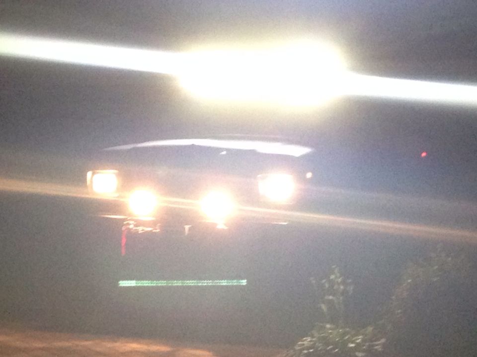 1979 Ford Bronco front view at night, headlights illuminated