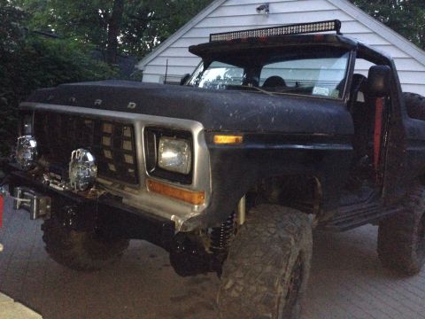 1979 Ford Bronco - This modified Ford Bronco features a prominent grille and an overhead light bar, suggesting an older model year.