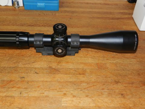 1996 Ford Bronco - A black rifle scope with adjustable turrets and objective bell is displayed on a wooden surface.