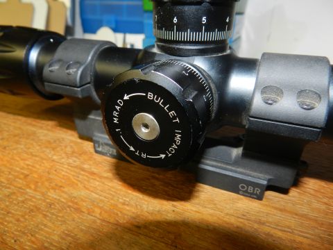 1996 Ford Bronco - Close-up of a rifle scope's elevation turret, indicating adjustments for bullet impact.