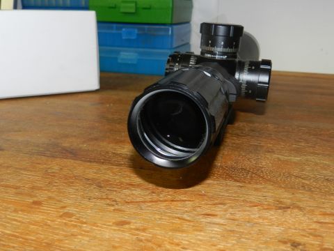 1996 Ford Bronco - Rifle scope with adjustable turrets and objective lens shown on a wooden table.