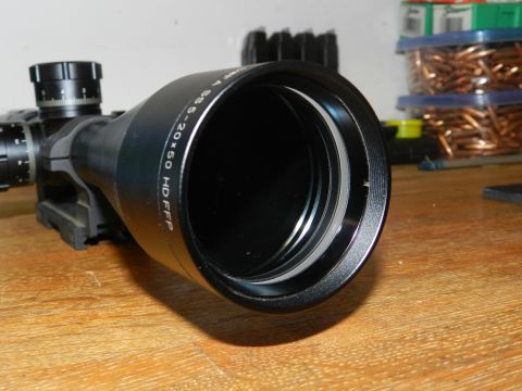 1996 Ford Bronco - A rifle scope is shown on a wooden table, with ammunition containers in the background.