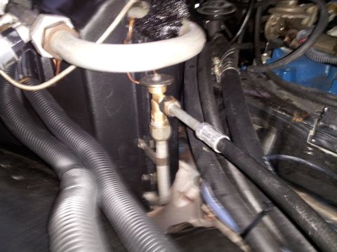 1976 Ford Ranchero - This image shows a close-up view of vehicle air conditioning system components, including an expansion valve and various hoses.