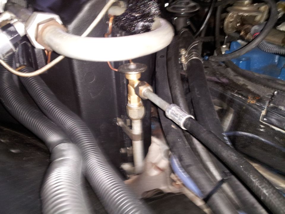 Close-up of AC expansion valve and hoses in engine bay