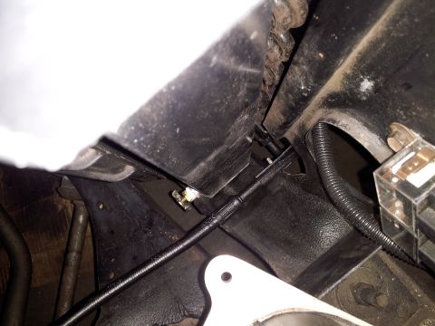 1976 Ford Ranchero - A close-up view of a black cable and white bracket, likely part of a vehicle's air conditioning system.
