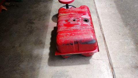 1983 Ford Bronco - A red fuel tank sits on a stool, likely in a garage or workshop.