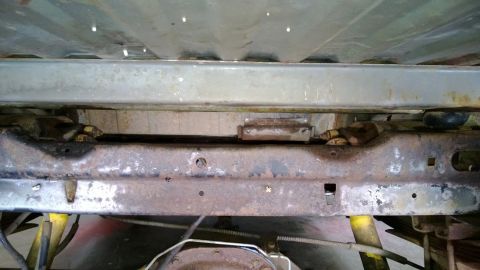 1983 Ford Bronco - The underside of a vehicle shows significant rust on its frame and suspension components.