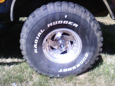 1979 Ford Bronco - A close-up view of a large off-road tire and custom wheel, 'Radial Mudder Buckshot' branding.
