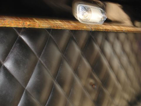 1979 Ford Bronco - Close-up of a vehicle's interior panel showing quilted upholstery and a light fixture.