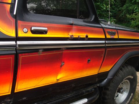 1979 Ford Bronco - This 1979 Ford Bronco shows damage from bullet impacts on its side panel, a distinctive gradient paint job.