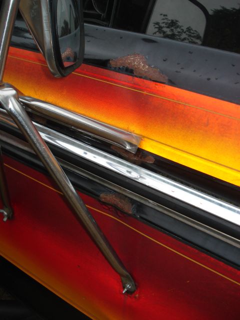 1979 Ford Bronco - Rust is visible on the door of this vehicle, which features a red, orange, and yellow flame graphic.