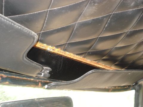 1979 Ford Bronco - Close-up of the interior headliner and trim, showing diamond stitching and some wear.