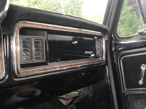 1979 Ford Bronco - Close-up of a vintage vehicle's dashboard, showing wood grain accents and the 'Ranger' emblem.