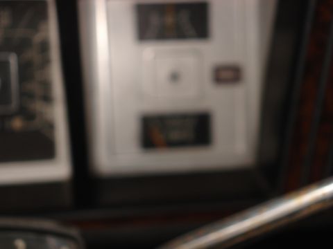 1979 Ford Bronco - The dashboard of a vehicle shows several gauges and warning lights, with a chrome trim piece visible.