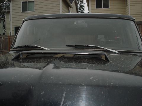 1979 Ford Bronco - Front view of a black vehicle's hood and windshield, a hood scoop.