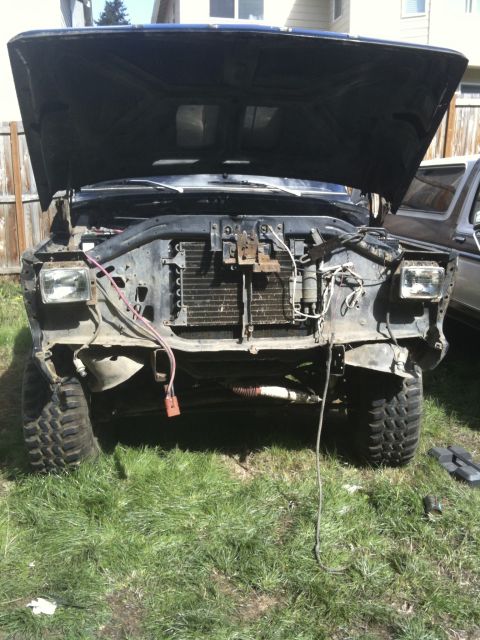 1979 Ford Bronco - The front end of a truck is disassembled, showing the radiator and engine components under an open hood.