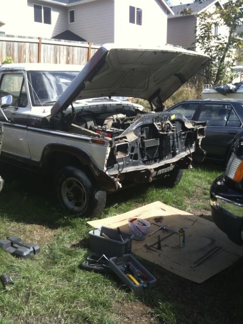 1979 Ford Bronco - A 1979 Ford Bronco is undergoing repairs in a yard, with tools laid out on cardboard.
