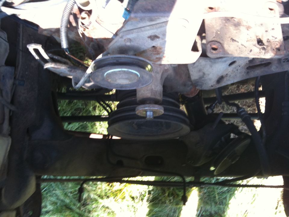 Engine bay view showing multiple pulleys and hoses. Some metal brackets are visible