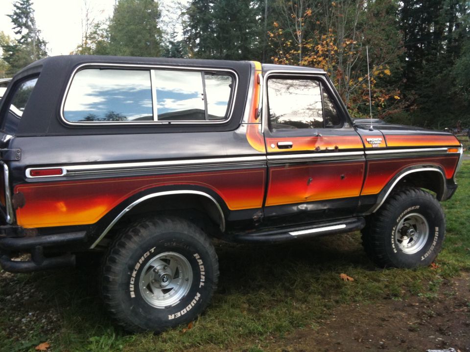 Side view of a 1979 Ford Bronco with sunset paint and lifted suspension