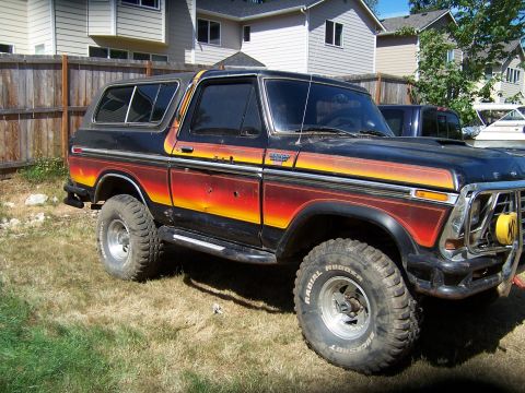 1979 Ford Bronco - A classic Ford Bronco sits in a grassy yard with houses in the background.